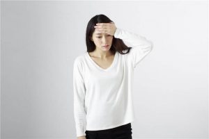 頭を押さえる女性